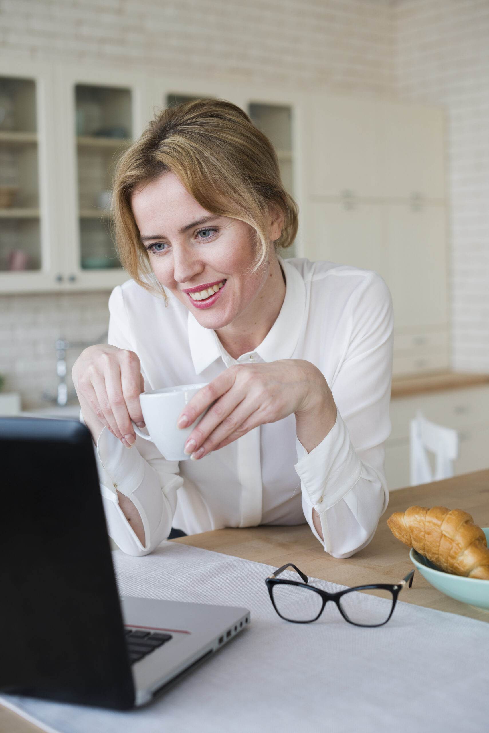 joyful business woman with coffee using laptop scaled